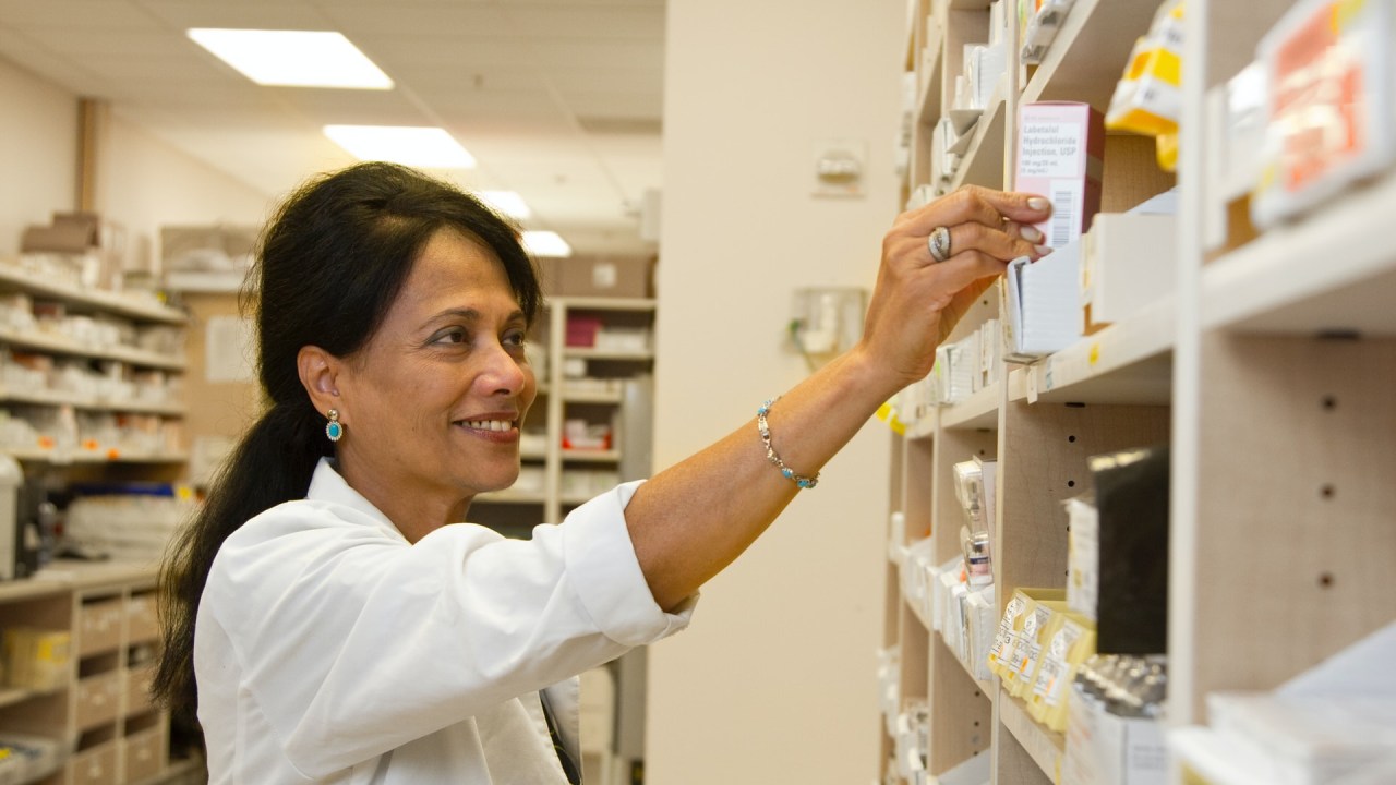 Farmacêutica organizando os remédios em uma farmácia.