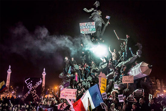 Manifestantes em torno da escultura O Triunfo da República, em Paris, protestam contra o terrorismo após os atentados contra o jornal satírico Charlie Hebdo em janeiro de 2015 (Crédito foto: Corentin Fohlen/World Press Photo 2016).