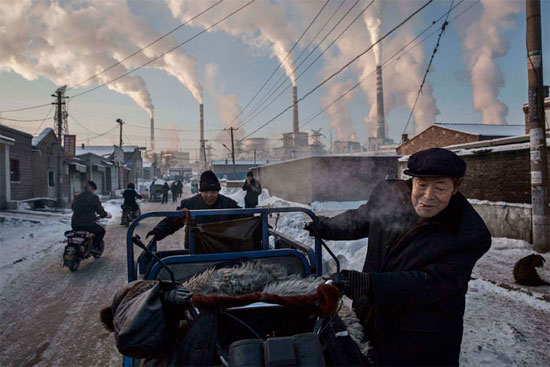 Homens carregam um triciclo em região próxima à usina de carvão em Shanxi, na China. O país é responsável por quase um terço de todo o dióxido de carbono emitido no planeta. O uso do carvão para a geração de energia é uma das principais causas do aquecimento global (Crédito foto: Kevin Frayer/Getty Images). Homens carregam um triciclo em região próxima à usina de carvão em Shanxi, na China. O país é responsável por quase um terço de todo o dióxido de carbono emitido no planeta. O uso do carvão para a geração de energia é uma das principais causas do aquecimento global (Crédito foto: Kevin Frayer/Getty Images).