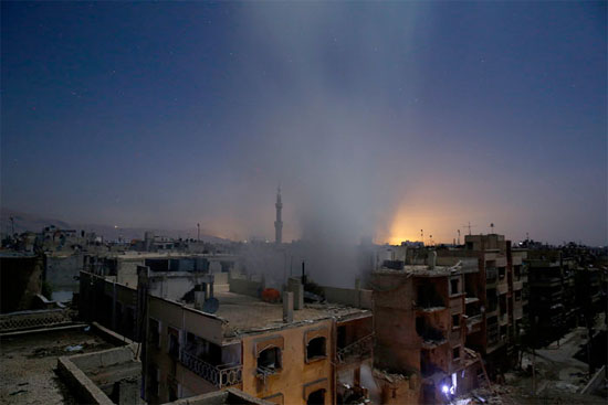 A imagem mostra edifícios na cidade de Douma, na Síria, após bombardeios das forças do governo. Douma é controlada por grupos rebeldes que tentam derrubar o ditador Bashar al-Assad e é alvo de uma série de ataques aéreos do regime sírio (Crédito foto: Sameer Al-Doumy/Agence France Presse).