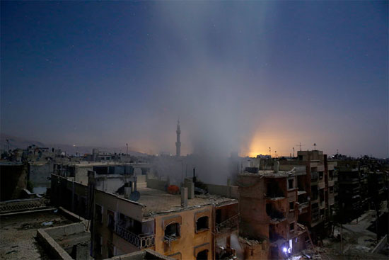 A imagem mostra edifícios na cidade de Douma, na Síria, após bombardeios das forças do governo. Douma é controlada por grupos rebeldes que tentam derrubar o ditador Bashar al-Assad e é alvo de uma série de ataques aéreos do regime sírio (Crédito foto: Sameer Al-Doumy/Agence France Presse). A imagem mostra edifícios na cidade de Douma, na Síria, após bombardeios das forças do governo. Douma é controlada por grupos rebeldes que tentam derrubar o ditador Bashar al-Assad e é alvo de uma série de ataques aéreos do regime sírio (Crédito foto: Sameer Al-Doumy/Agence France Presse).