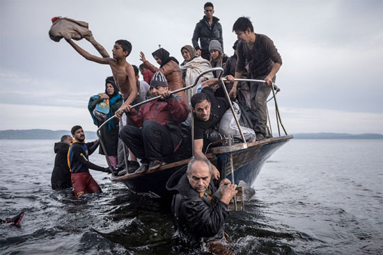 Pequena embarcação com refugiados chega à vila de Skala, na ilha de Lesbos, na Grécia (Crédito foto: Sergey Ponomarev/The New York Times). Pequena embarcação com refugiados chega à vila de Skala, na ilha de Lesbos, na Grécia (Crédito foto: Sergey Ponomarev/The New York Times).