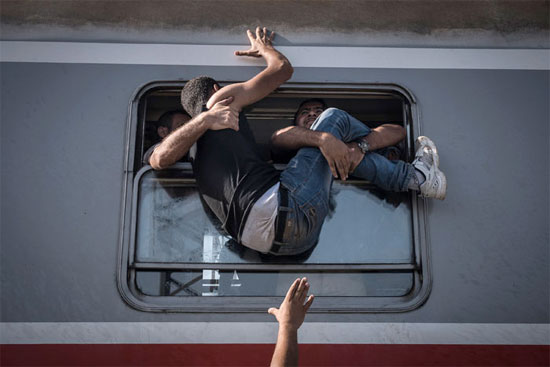 Refugiados tentam embarcar em um trem em Tovarnki, na Hungria, com destino a Zagreb, na Croácia (Crédito foto: Sergey Ponomarev/The New York Times). Refugiados tentam embarcar em um trem em Tovarnki, na Hungria, com destino a Zagreb, na Croácia (Crédito foto: Sergey Ponomarev/The New York Times).