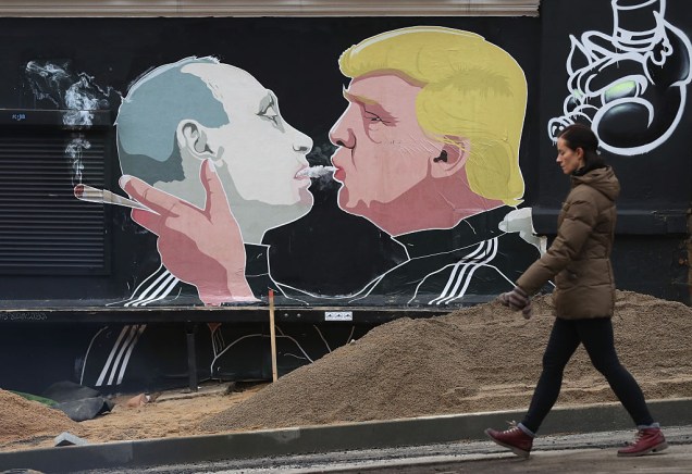 <span>O grafite de Berlim ainda influencia as novas gerações. Na fachada deste bar em Vilnius, capital da Lituânia, a imagem do “beijo fraterno” inspirou este grafite que mostra os presidentes da Rússia, Vladimir Putin, e dos Estados Unidos (EUA), Donald Trump. O beijo da imagem original é substituído por uma baforada de maconha de Trump na boca de Putin. O grafite, com grande dose de ironia, revela o temor da população da Lituânia em relação a uma possível intervenção da Rússia para anexar o país. A aproximação entre Putin e Trump é vista com preocupação, uma vez que o presidente norte-americano poderia abrir mão de defender a Lituânia em caso de uma invasão russa. </span>(foto: Sean Gallup/Getty Images)