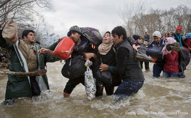 Uma mulher é carregada por dois homens enquanto cruzam um rio, em março de 2016. São refugiados que abandonaram um campo de refugiados na Grécia e  tentam chegar à Macedônia.
<div id="desc-default"><span>(foto: Vadim Ghirda/World Press Photo 2017)</span></div>