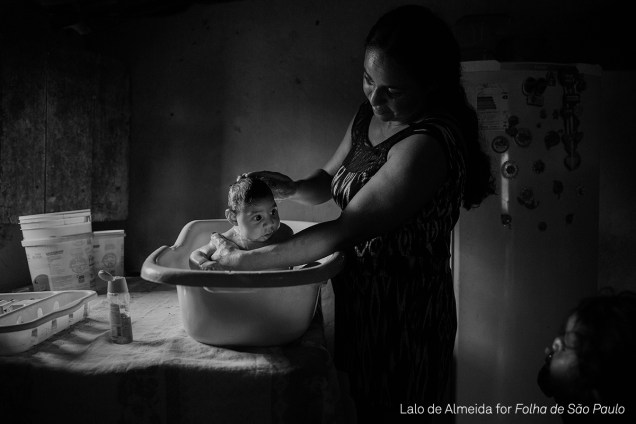 Adriana Cordeiro Soares, banha seu filho, João Miguel de três meses, em outubro de 2016, na zona rural de <span>São Vicente do Seridó (PB)</span>. O bebê nasceu com microcefalia, provocada pela contaminação da mãe pelo vírus da zika
<div class="photo-desc">(foto: Lalo de Almeida/World Press Photo 2017)</div>