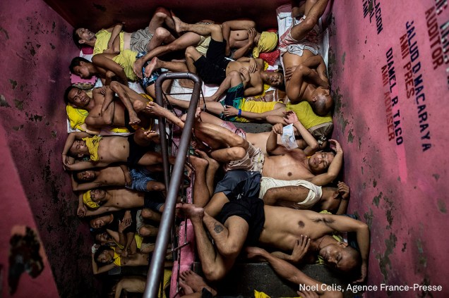 Detentos dormem nos degraus de uma escada na prisão de Quezon, em Manila, nas Filipinas, em julho de 2016. A guerra ao crime lançada pela polícia piorou as condições nas cadeias do país.
<div id="desc-default"> <span>(foto: Noel Celis/World Press Photo 2017)</span></div>