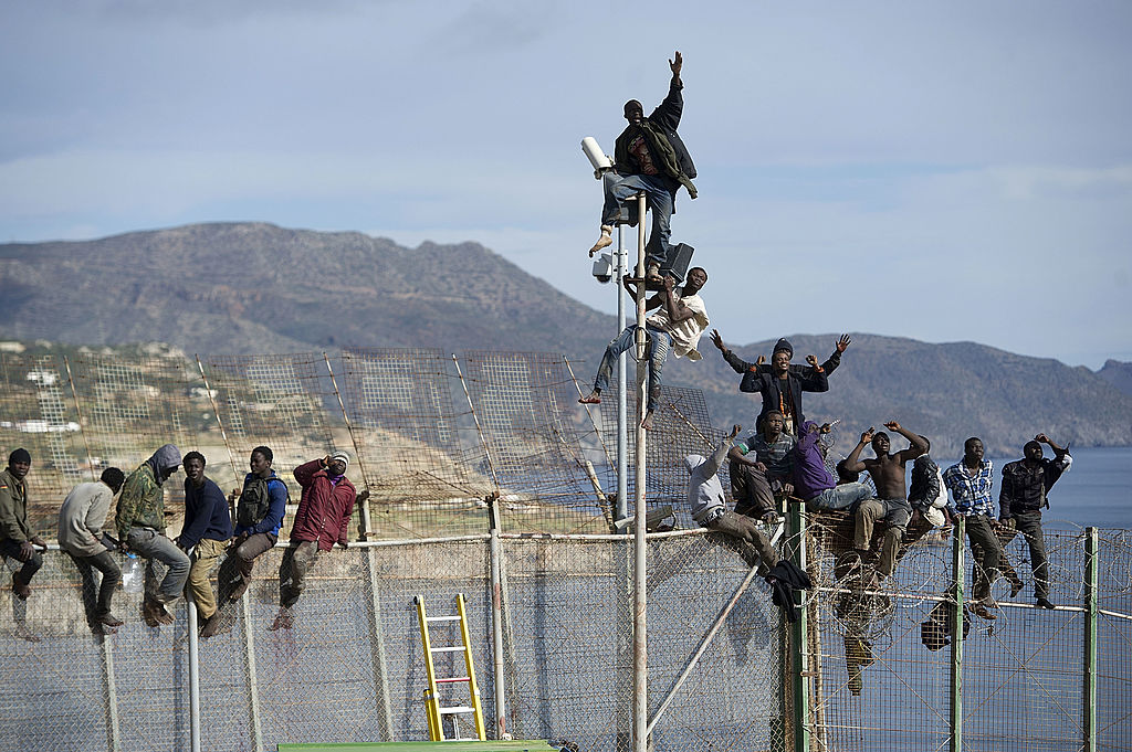 Imigrantes africanos escalam a cerca que separa o Marrocos do enclave espanhol de Melilla