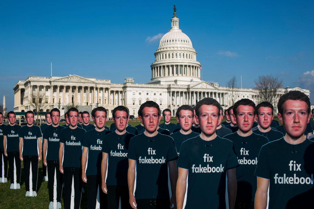 Cartazes em protesto contra Mark Zuckerberg, em frente ao Congresso norte-americano, em abril de 2018. A inscrição na camiseta diz "conserte o Facebook"