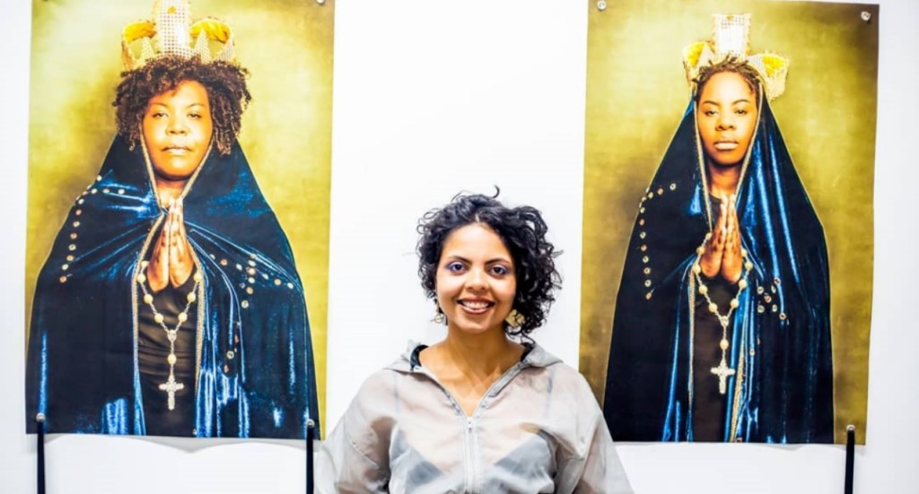 Linoca Souza ao lado de duas imagens de mulheres negras vestidas como figuras religiosas católicas