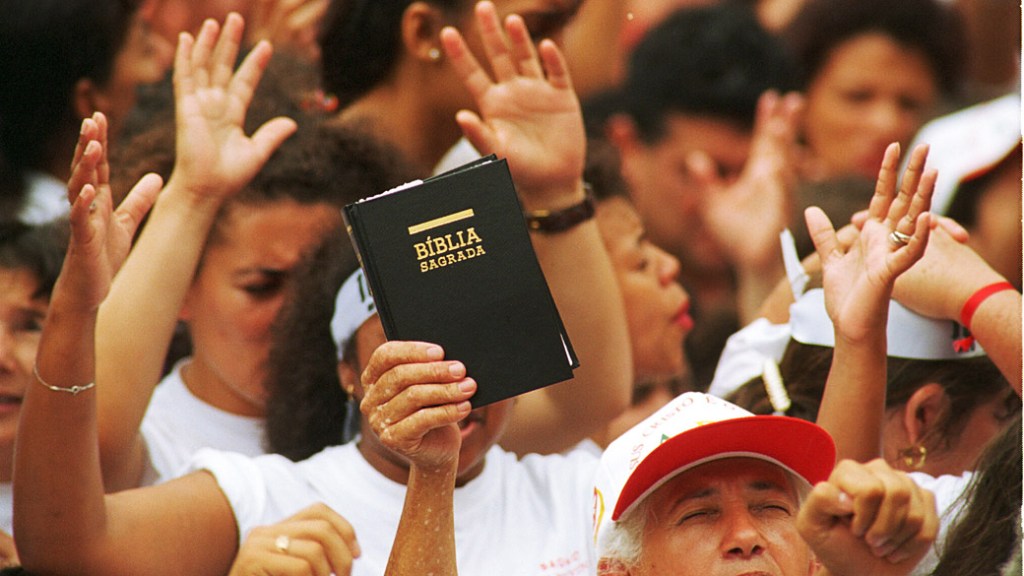 Homem segura uma bíblia em culto de uma igreja evangélica neopentecostal