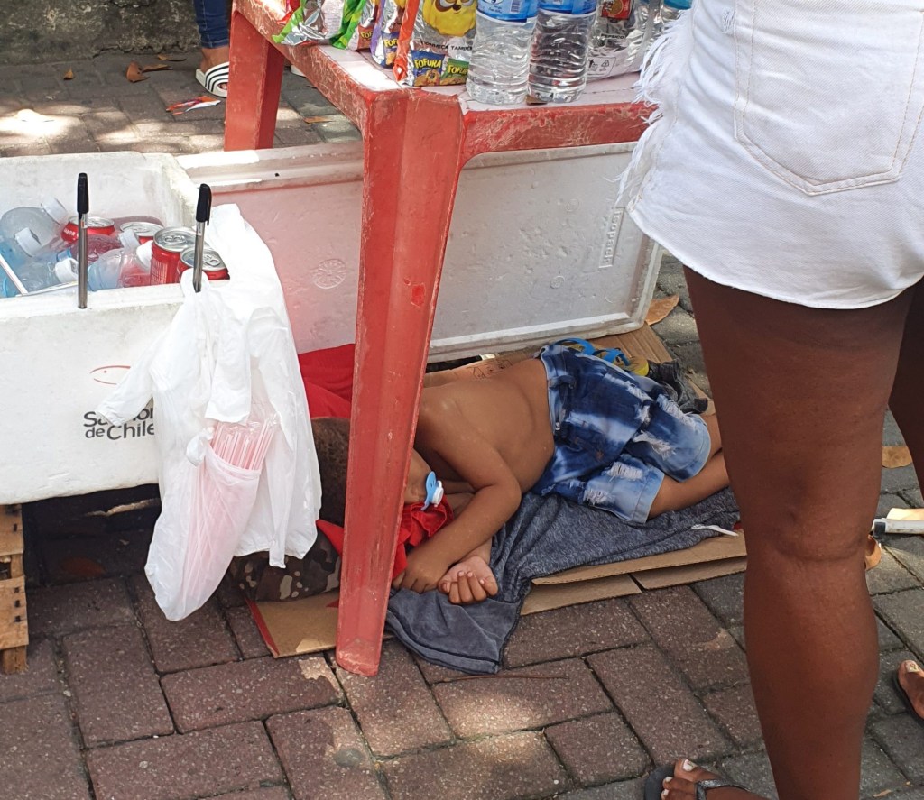 Criança dorme sob banca de ambulante na entrada do Enem