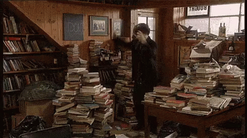 Homem dançando entre pilhas de livros