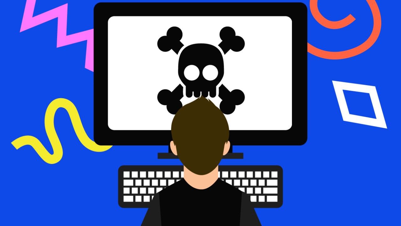 Pessoa de costas ao centro, em frente a um computador e um teclado. Na tela, uma caveira e dois ossos, símbolo da pirataria.