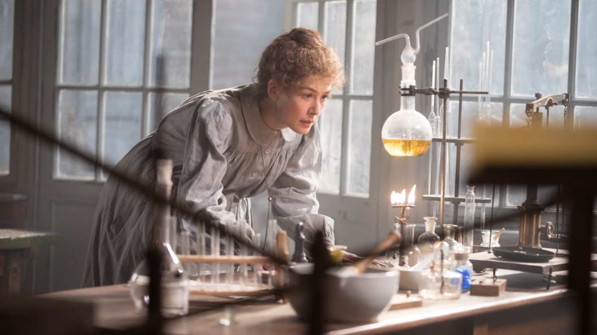 A atriz Rosamund Pike num laboratório como Marie Curie no filme Radioativo