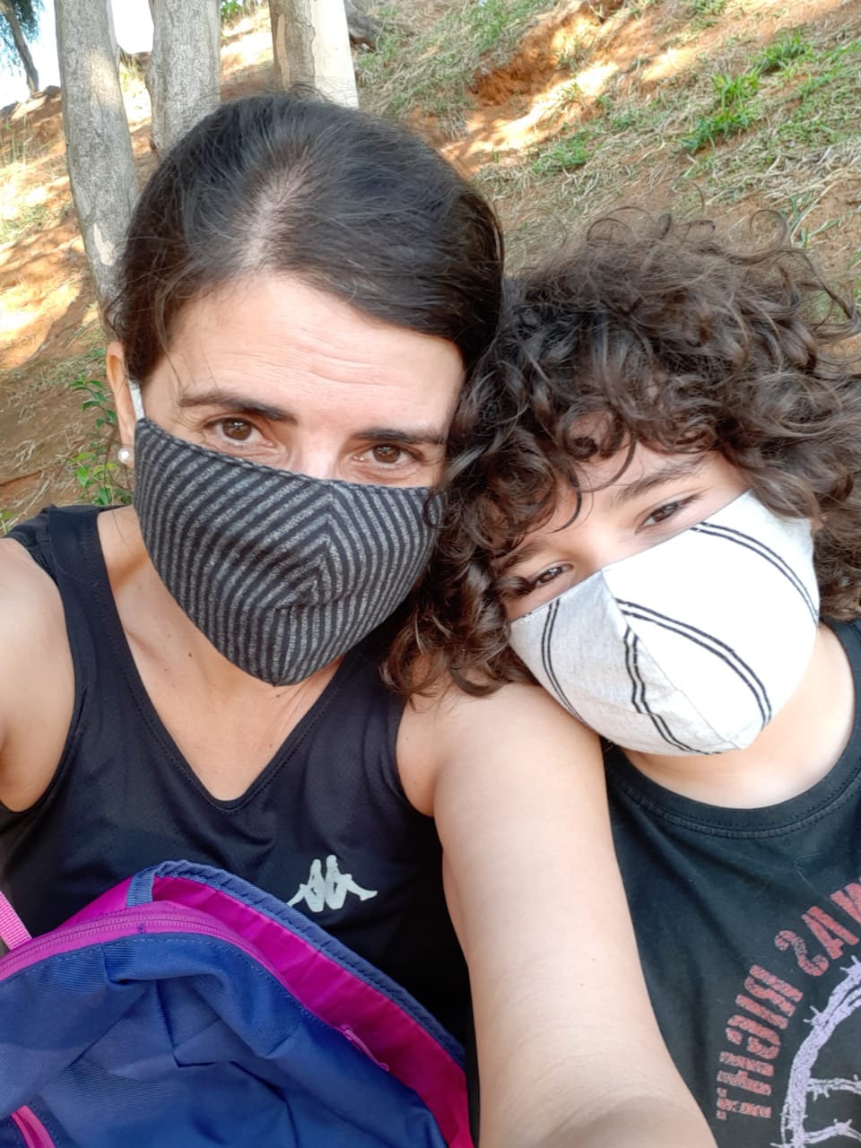 Mãe e filho de máscara no parque