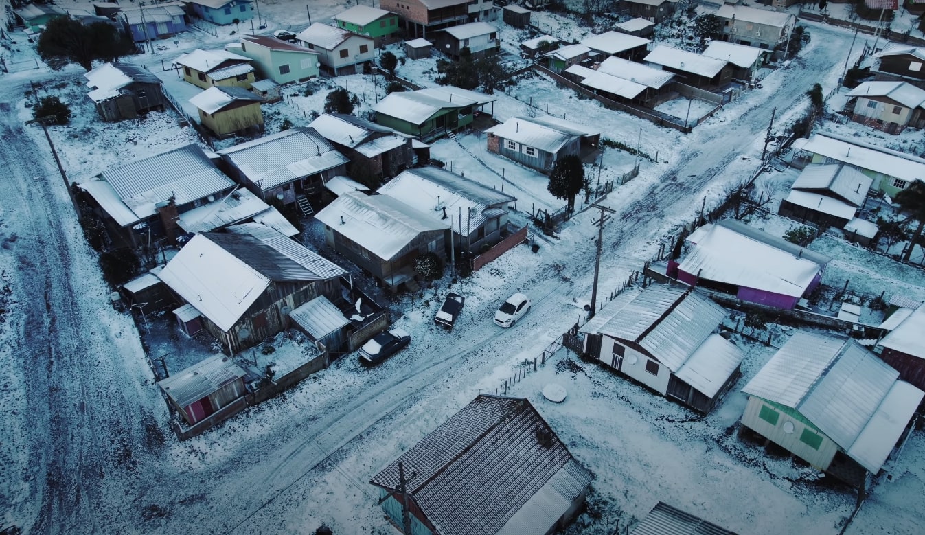 Foto panorâmica tirada em um drone registra a cidade de Cambará do Sul coberta de neve.