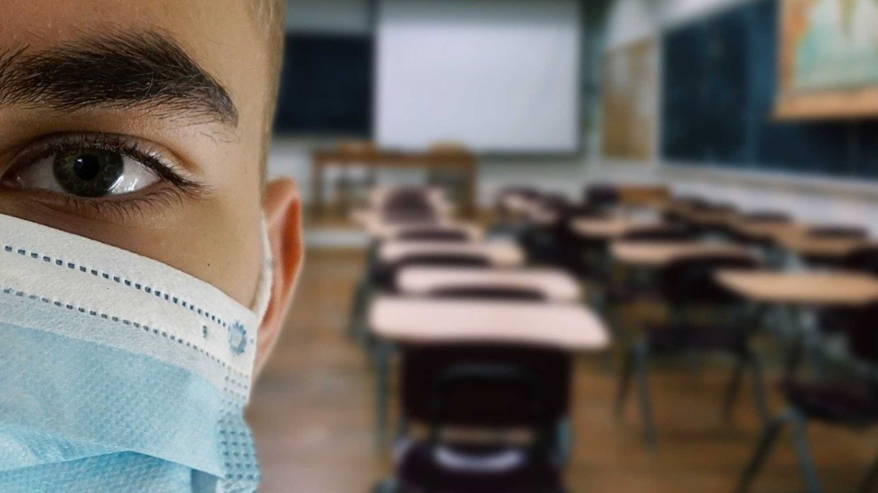 Estudante de máscara em uma sala de aula