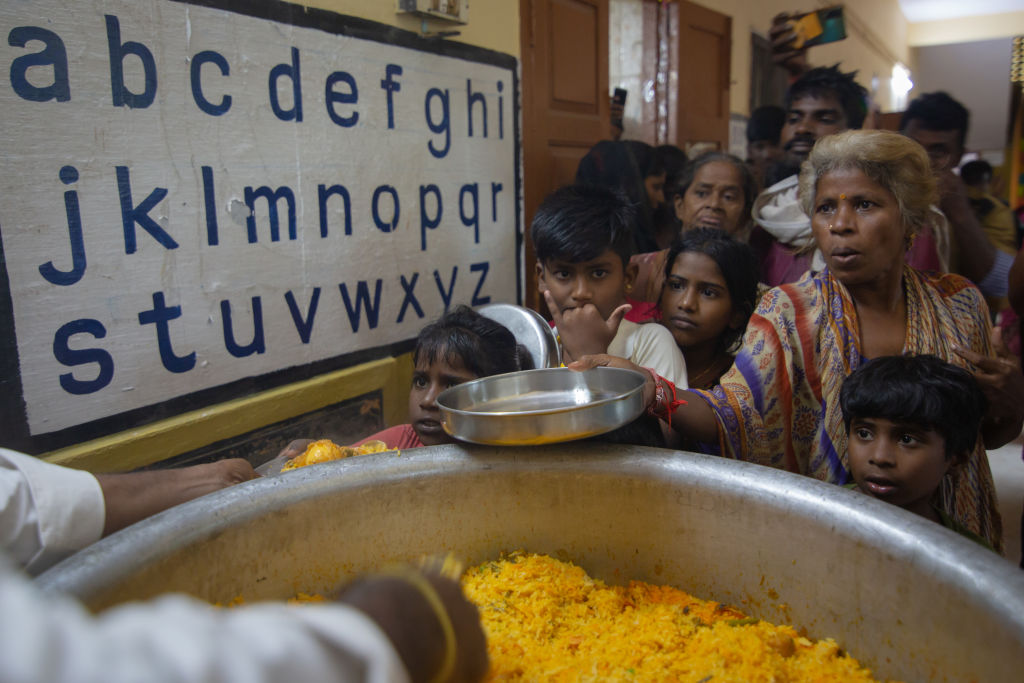 Indiana vítima de enchente estende um prato para receber comida