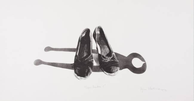 Obra da artista Regina Silveira. Há dois sapatos no chão. A foto está em preto e branco.