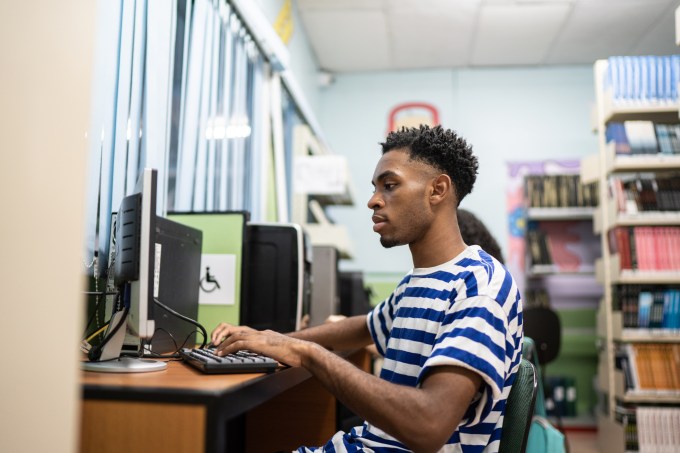 Young man using computer in a library