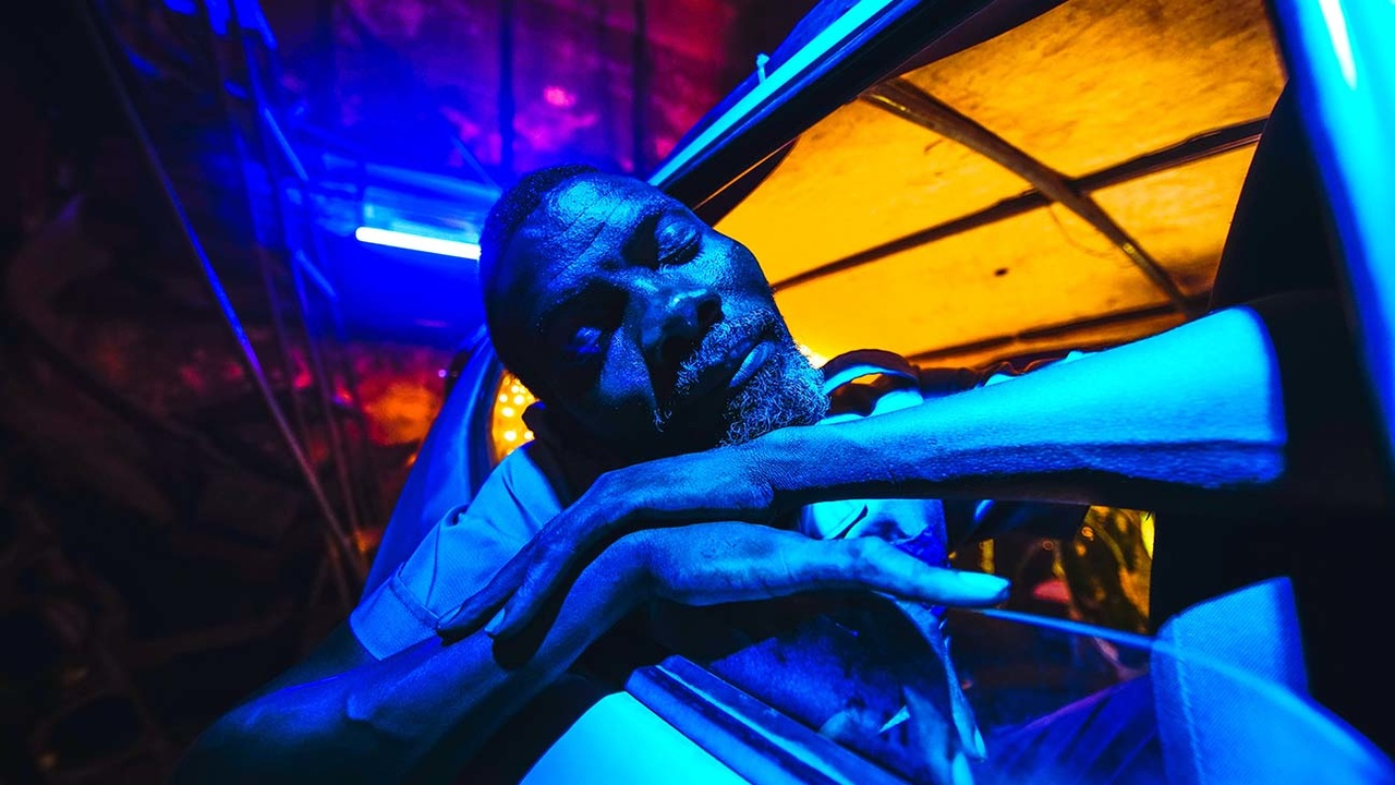 Foto promocional do filme "Ar Condicionado", de 2020, com um homem com a cabeça apoiada na janela de um carro.