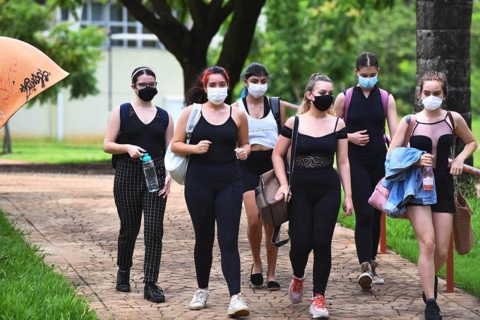 Grupo de jovens andando e usando máscara