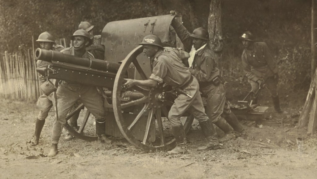 Homens militares preparam um canhão
