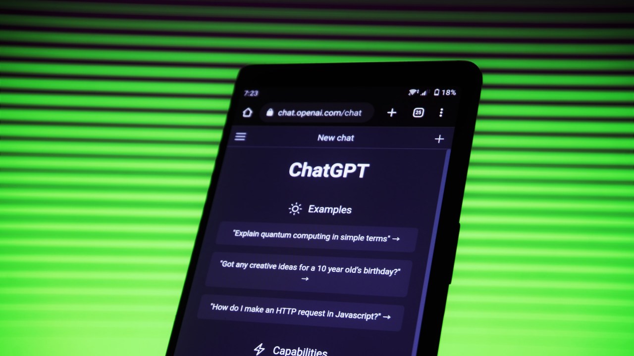 Tela de celular aberta na página do ChatGPT. Ao fundo, uma parede com luzes verdes.