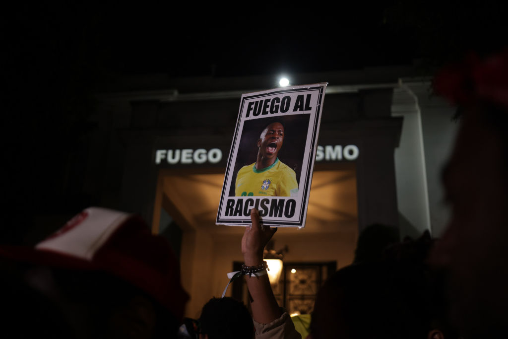 imagem mostra um cartaz com o rosto de vinicius junior e a frase "fogo no racismo"
