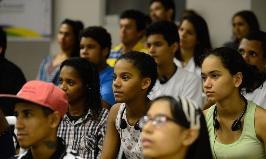 Jovens-estudantes Grupo de jovens sentados olhando para a direita