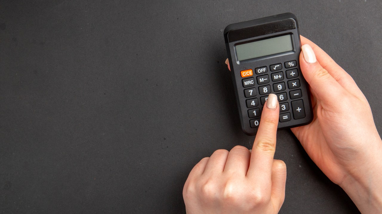 calculadora, fundo preto, mãos