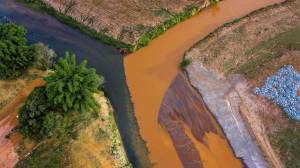 Biodiversidade-desastre-Mariana-GettyImages-622857288 O rio Gualaxo do Norte despeja lama tóxica vinda da barragem da Samarco, em Mariana (80 km rio acima), no rio Carmo (à esq.), em foto de 2016; cerca de 25 km depois, a lama atinge o rio Doce, um dos mais importantes do Sudeste do Brasil