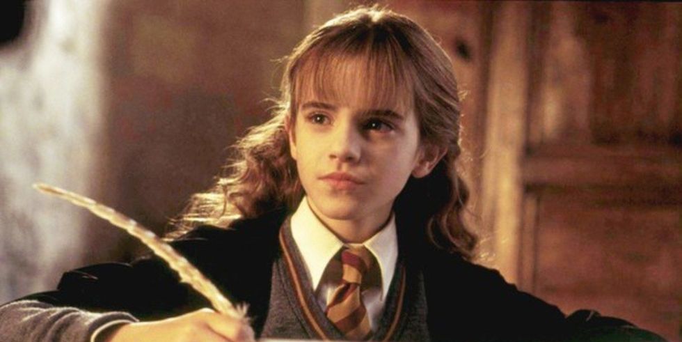 imagem mostra a atriz emma watson interpretando hermione granger. É uma menina de cabelos castanhos e enrolados