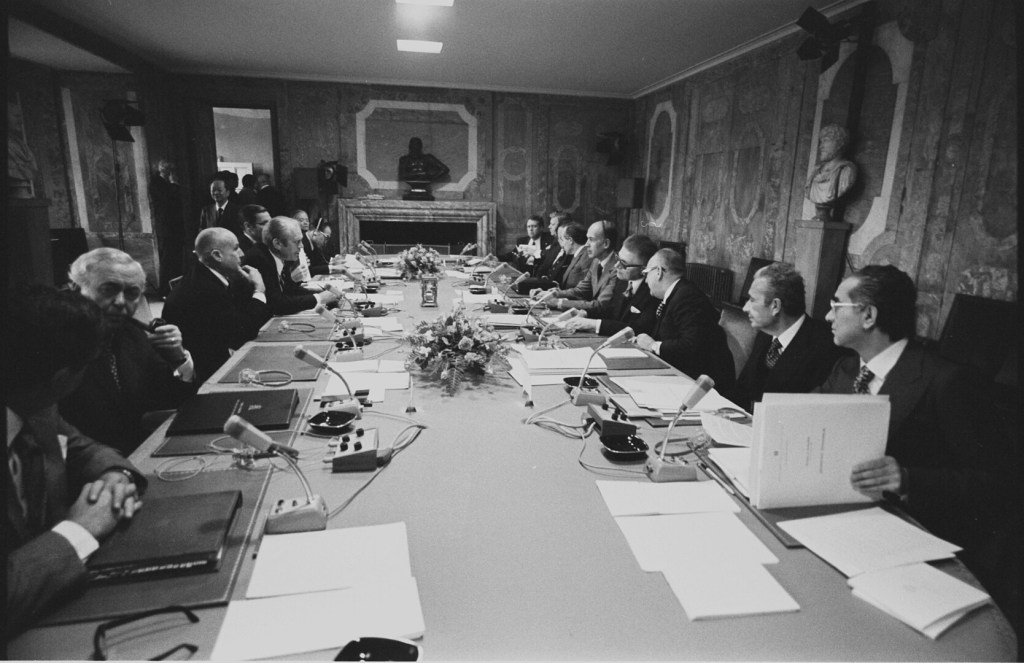 Encontro do G7, em 1975, mostra líderes durante reunião em uma mesa