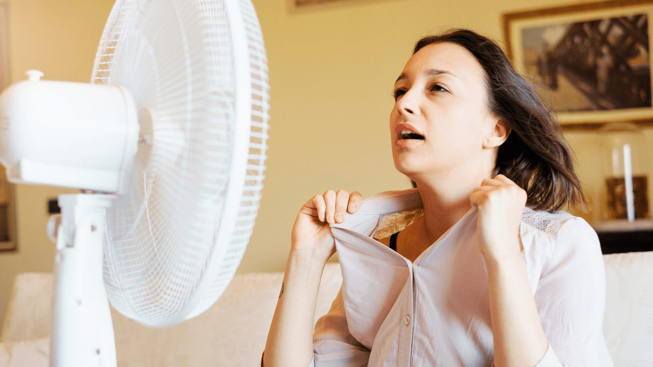 Mulher suando em frente a um ventilador