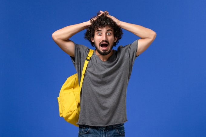 front-view-young-male-grey-t-shirt-wearing-yellow-backpack-blue-wall