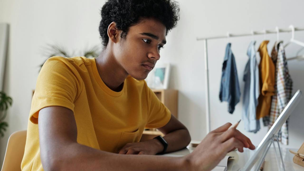 adolescente de camiseta amarela usando tablet