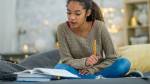 menina sentada no sofá estudando