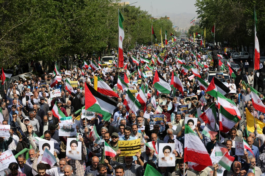Manifestação em Teerã, em 19 de abril, contra o ataque de Israel ao país, na qual se veem bandeiras do Irã e da Palestina e cartazes com o rosto do aiatolá Khomeini