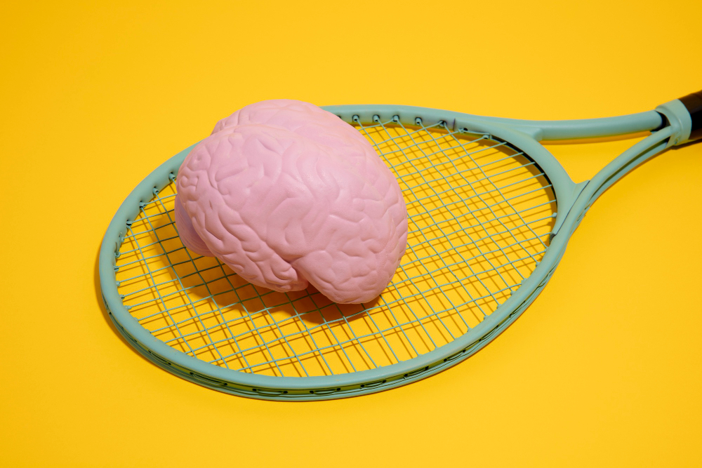 Cérebro de brinquedo em cima de uma raquete de tênis