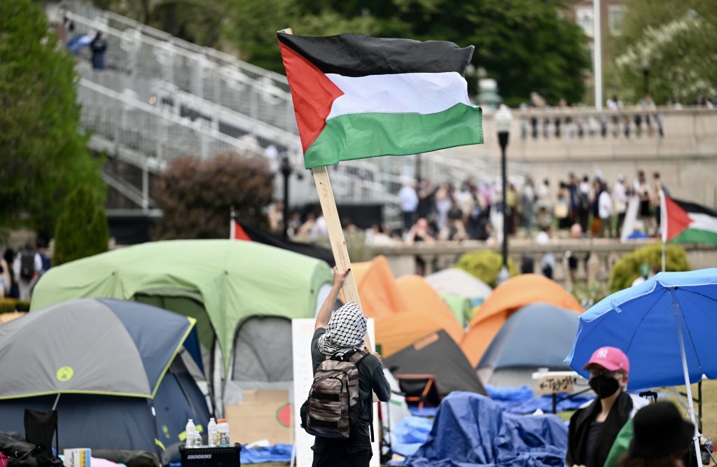 estudante com bandeira da Palestina em acampamento na Universidade de Columbia