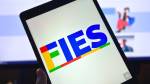 Tablet com logo do Fies à frente de tela de monitor com site do Fies aberto