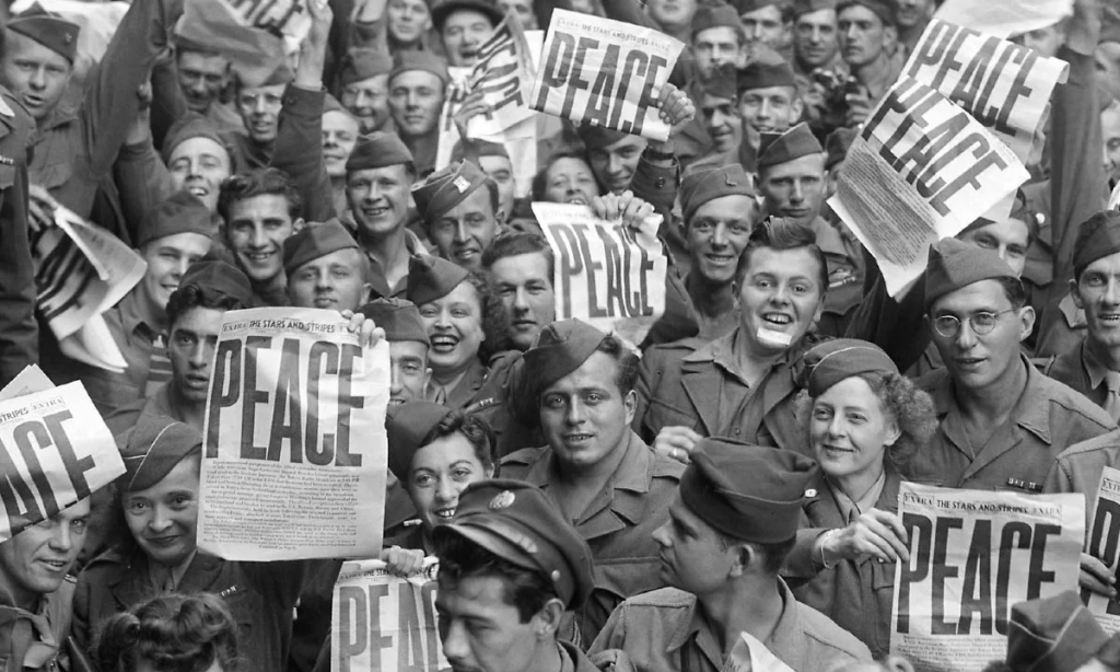 fim-da-segunda-guerra-mundial População se amontoa celebrando fim da guerra, seguram jornal que estama