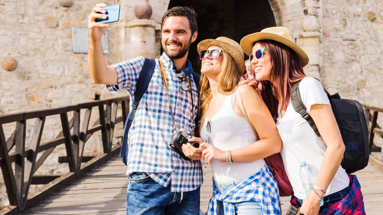 3 amigos em lugar histórico, tirando uma selfie